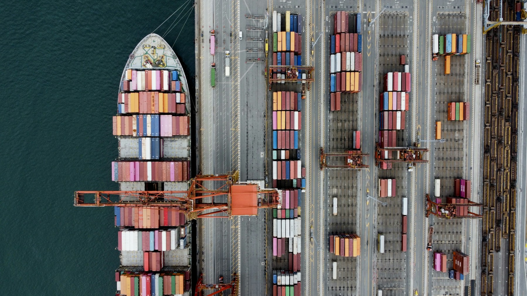 Aerial view of a container ship, colourful shipping containers and cranes at a port in Vancouver
