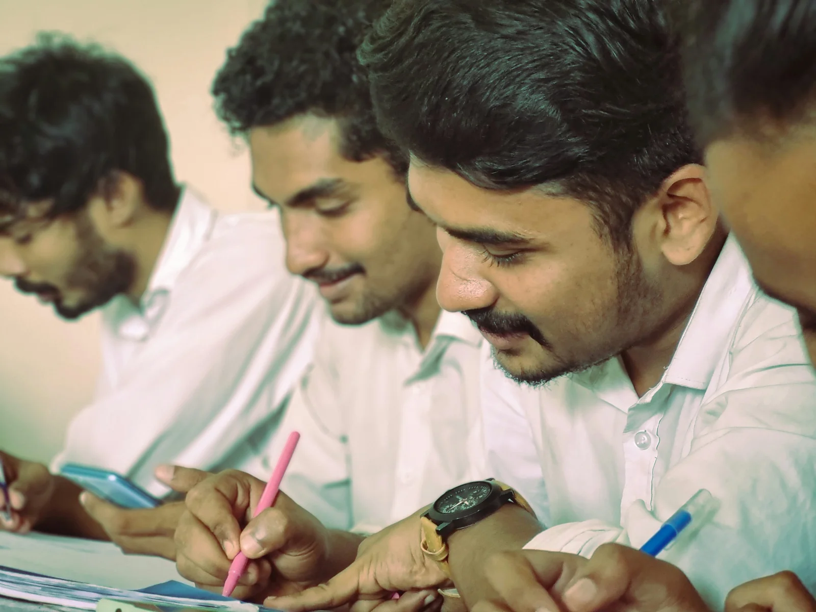 Students taking notes together during a class in Kerala